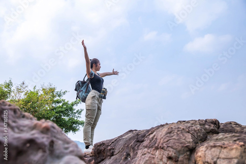 woman hiker with backpack hiking in the top of the mountain