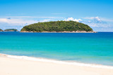 Turquoise Sea and White Sand Beach at Nai Harn Beach with Ko Man Island Background in Summer, Phuket, Thailand