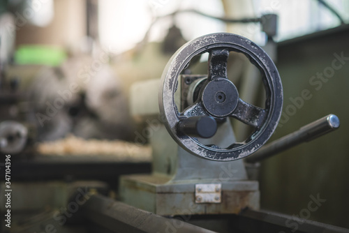 The controller wheel part of the retro Lathe machine in the workshop. © Peerapat Lekkla