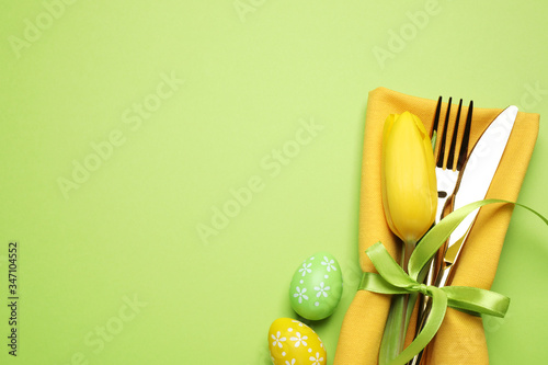 Photography Top view of cutlery set with floral decor on green background, space for text
