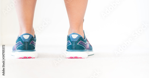 Teal blue running shoes - Jogging keeps you healthy - Young attractive woman s legs and shoes - Stay active