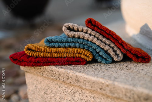 knitted hats of different colors lie on a marble slab