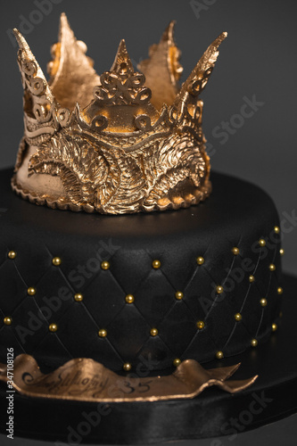 Black cake with a Golden crown of mastic