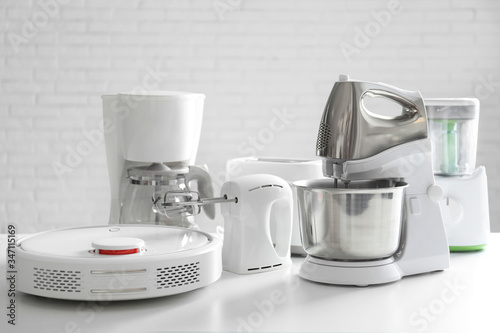 Set of modern home appliances on white table