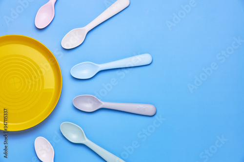Plasic fork and spoon heading plate on black background, top view