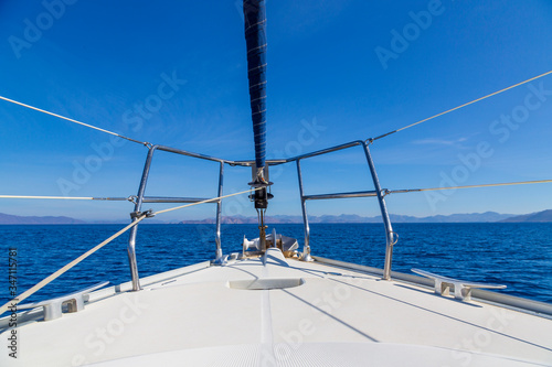 The front bow of a white sailing boat with blue sky and sea background. Love in blue with copy space