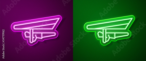 Glowing neon line Hang glider icon isolated on purple and green background. Extreme sport.  Vector Illustration