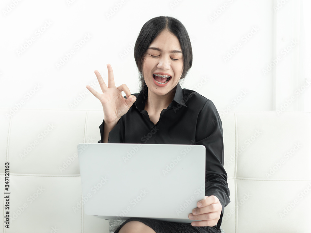 Asian woman in blank using laptop sitting on sofa at home, quarantine concept. Asian woman in blank using laptop sitting on sofa at home, quarantine concept.