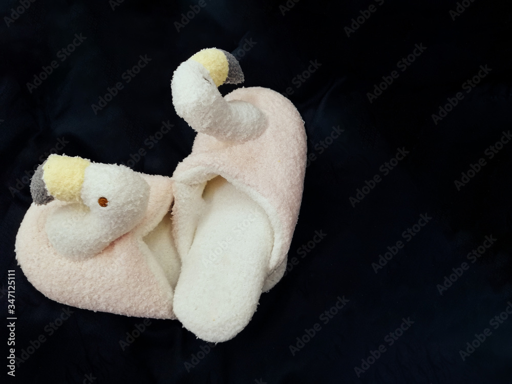 Flamingo Slippers on a dark background. Fluffy pink trendy slippers with flamingo Flamingo Slippers on a dark background. Fluffy pink trendy slippers with flamingo