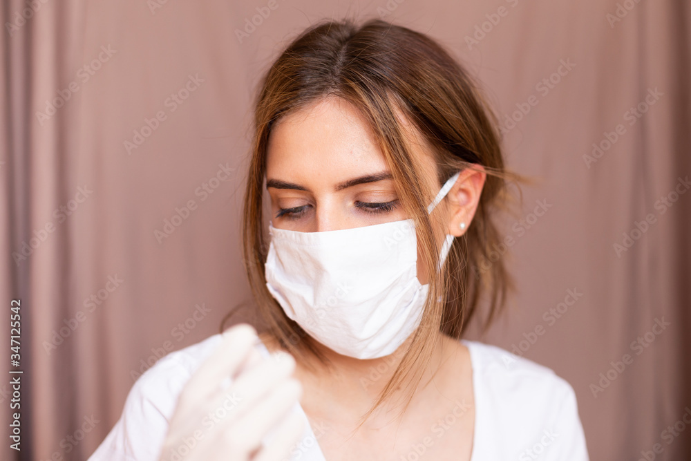 portrait of beautiful young woman wearing cotton white mask and medical/surgical gloves on pastel background. portrait of beautiful young woman wearing cotton white mask and medical/surgical gloves on pastel background.