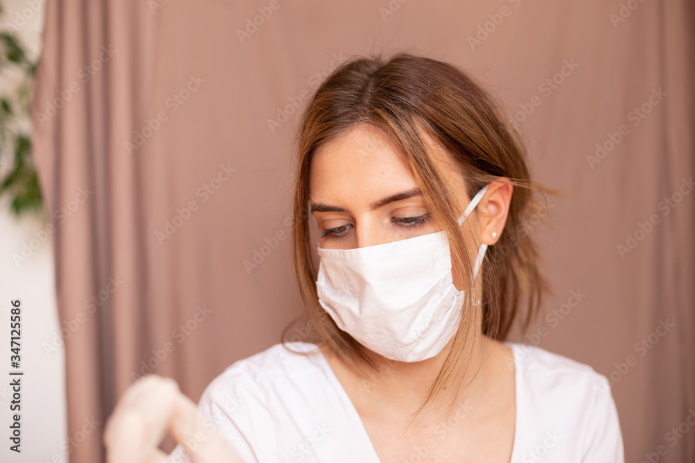 portrait of beautiful young woman wearing cotton white mask and medical/surgical gloves on pastel background. portrait of beautiful young woman wearing cotton white mask and medical/surgical gloves on pastel background.