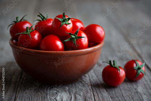 Fresh ripe organic cherry tomatoes on dark background
