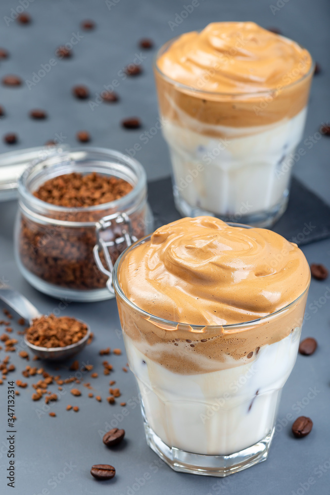 Dalgona coffee with ice, trendy korean drink on a dark gray background, vertical