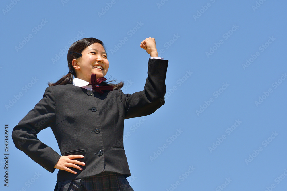 青空でガッツポーズをする女の子