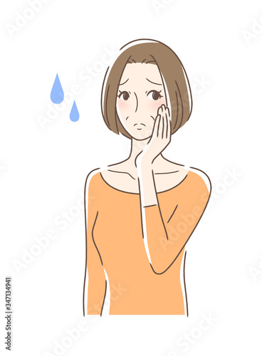 不安そうに頬を触る女性