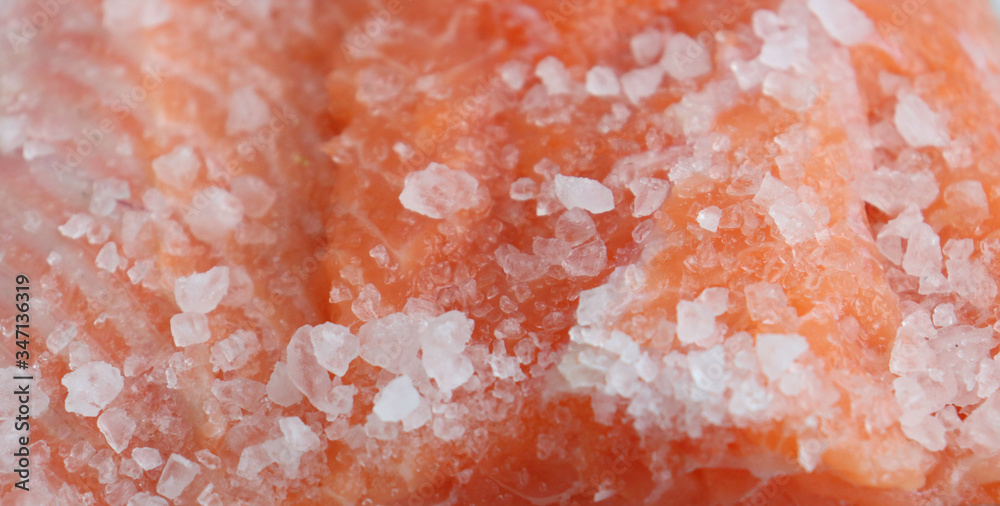 Fresh salmon filet under large sea salt. Close-up. Homemade salted fish, omega-3, proper nutrition. Expensive pleasure, the rise in price of seafood Fresh salmon filet under large sea salt. Close-up. Homemade salted fish, omega-3, proper nutrition. Expensive pleasure, the rise in price of seafood