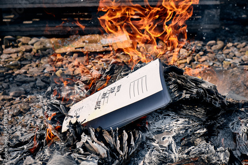 Closeup burning documents outdoors. Concept destruction by fire of evidence or correspondence.