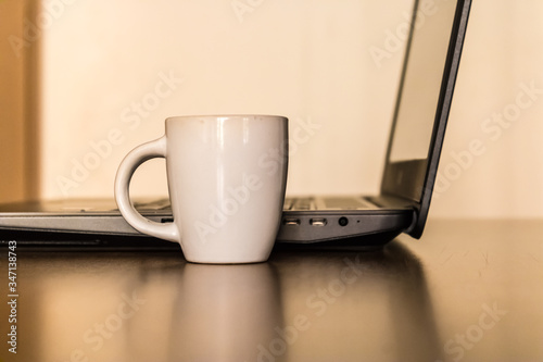 Office table desk with a small espresso coffee cup and laptop, work from home with coffee break, cozy home office - Image