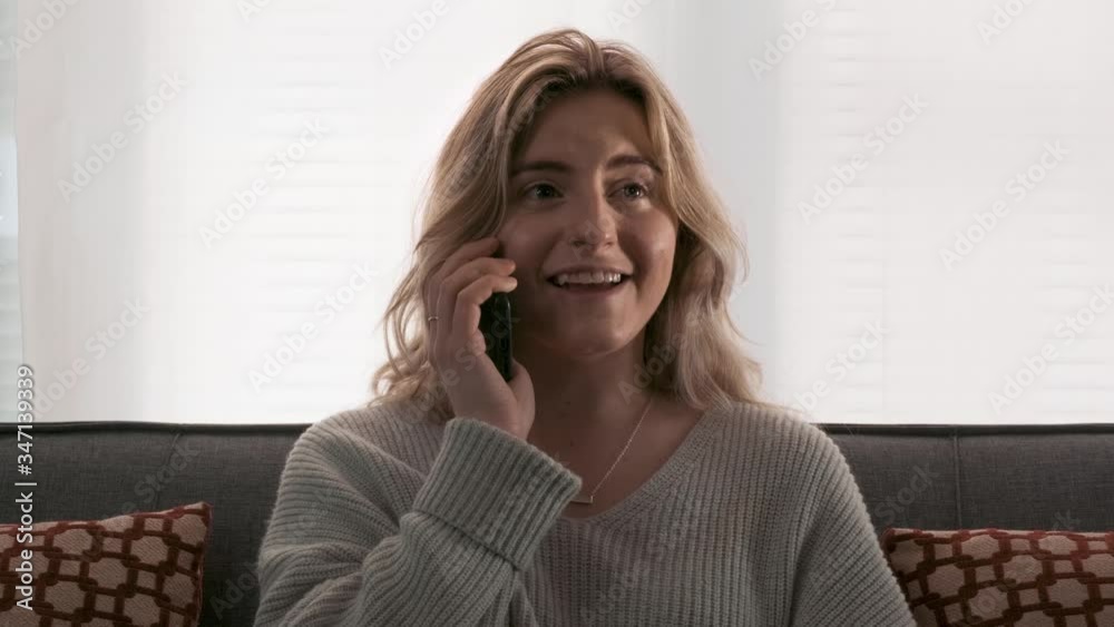Attractive young woman smiling and laughing on a phone conversation