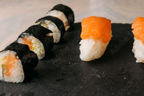 Sushi dish with maki and nigiri. Salmon, tuna, avocado and rice on a slate board
