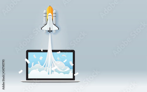 Startup business project concept with space shuttle launch from laptop screen on gray background