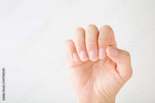 Fotografiet Young woman hand without nail polish on light gray background
