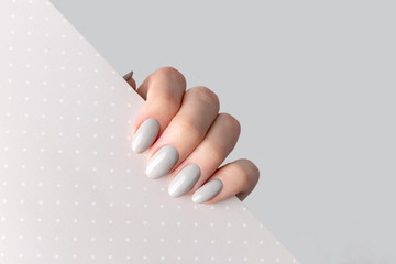 Leinwandbilder Nagelstudio Graue Maniküre auf Punkte-Hintergrund  © Darya Lavinskaya