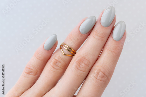 Beautiful womans hand with manicure close up on polka dot background