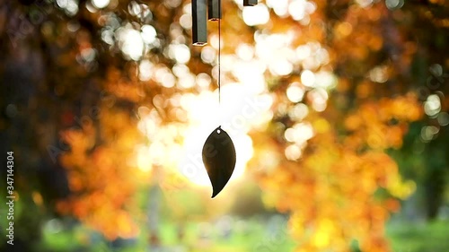 Stunning sunset backlighting slow motion wind chime in temple garden