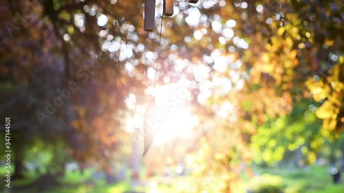 Stunning sunset backlighting slow motion wind chime in temple garden