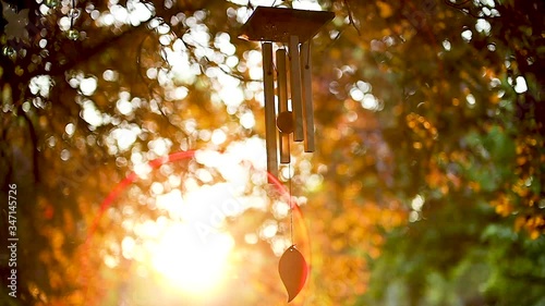 Stunning sunset backlighting slow motion wind chime in temple garden