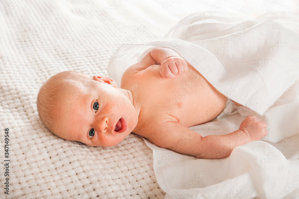 Newborn on the bed. Crying, screaming baby close up and copy space. Baby smile and colic in newborns. Seborrheic dermatitis in newborns Newborn on the bed. Crying, screaming baby close up and copy space. Baby smile and colic in newborns. Seborrheic dermatitis in newborns