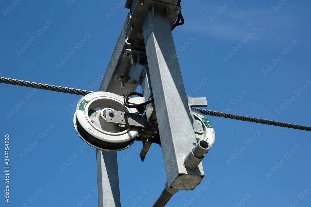Detail of cableway and ropeway - machinery and mechanism of wheel, rope and cable. Components are made of steel and metal. Clear blue sky as copy space. Detail of cableway and ropeway - machinery and mechanism of wheel, rope and cable. Components are made of steel and metal. Clear blue sky as copy space.