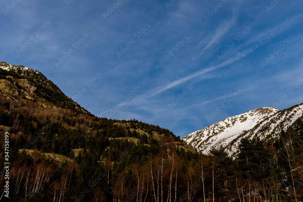 A picturesque landscape view of the Pyrenees mountain range and the dramatic blue sky in the Vall de Sorteny (Andorra) natural park on an early cold winter evening