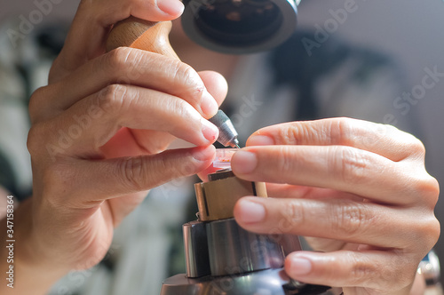 Technician delicately making  fine jewelry hand crafts on microscope