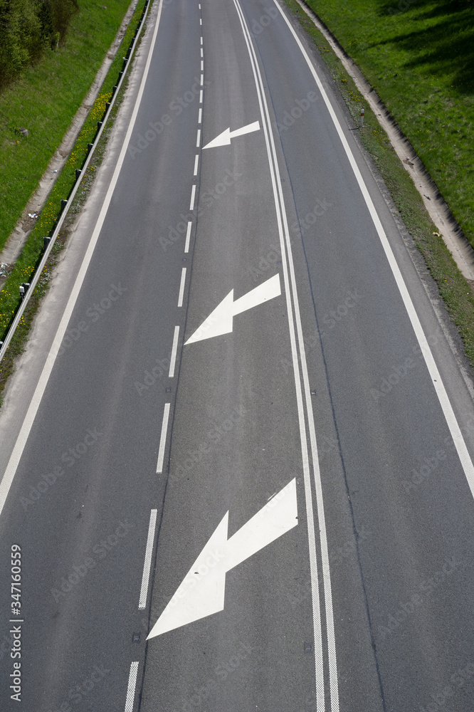 Road, roadway and motorway with lines and road surface marking. Road is empty and vacant. Green grass is around the road. View from above.