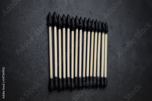 Biodegradable ear sticks and toothbrushes on a white and black background