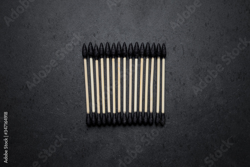 Biodegradable ear sticks and toothbrushes on a white and black background