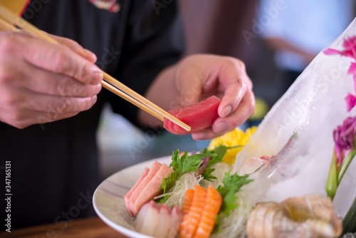 Sushi chef making japanese dish sasimi