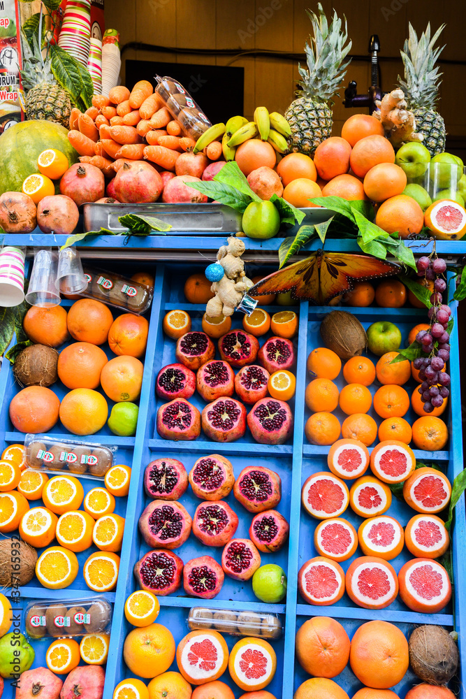 Juice bar background concept. Fresh exotic fruits wall Juicing Fresh Pomegranates Market Stall