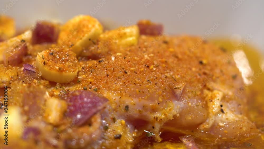 Raw chicken with garlic and seasoning ready for cooking - closeup Raw chicken with garlic and seasoning ready for cooking - closeup