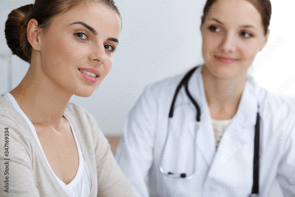 Doctor and patient are sitting and discussing health examination results in clinic office. Health care, medicine and good news concepts Doctor and patient are sitting and discussing health examination results in clinic office. Health care, medicine and good news concepts