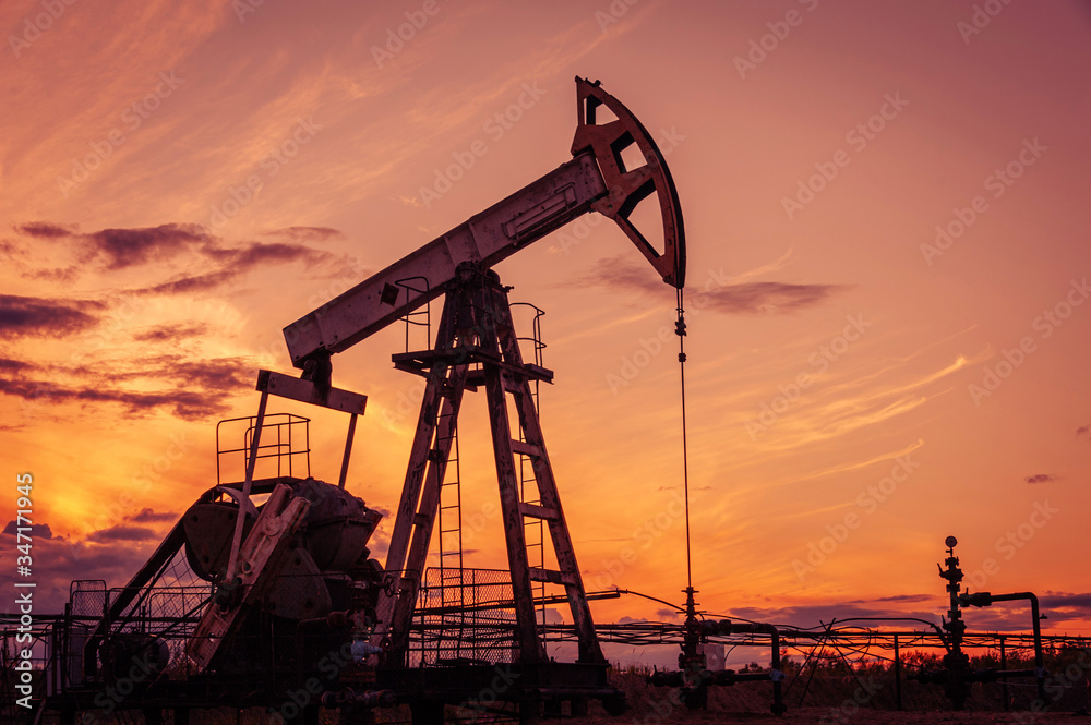 Oil pump rig. Oil and gas production. Oilfield site. Pump Jack are running. Drilling derricks for fossil fuels output and crude oil production. War on oil prices. Global coronavirus COVID 19 crisis.