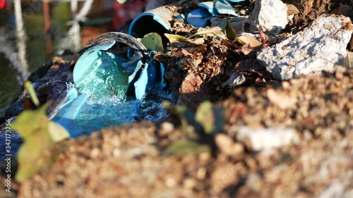 Water leaks out from big broken PVC, polyvinyl chloride, water pipe line on the roadside