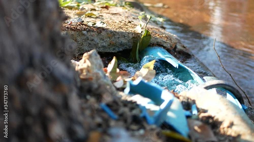 Water leaks out from big broken PVC, polyvinyl chloride, water pipe line on the roadside