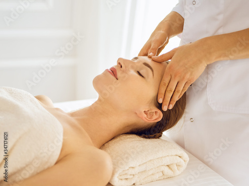 Beautiful woman enjoying facial massage with closed eyes