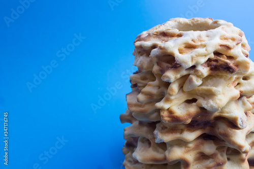 Lithuanian sakotis or raguolis traditional spit cake. blue background side view photo