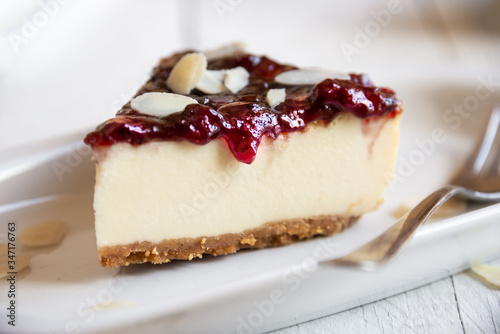 Homemade delicious cheesecake with fruit jam and almonds