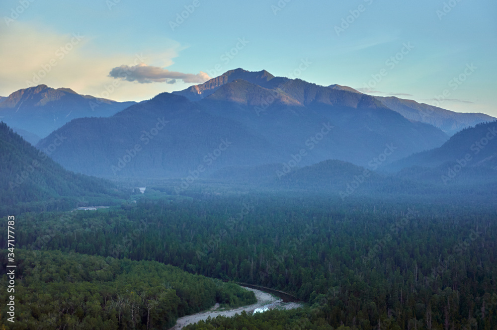 River valley in the forest surrounded by mountains.