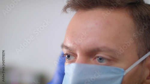 Medical worker in blue gloves puts on a medical mask. Health protection products.
